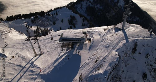 Villars chairlift over the fog, back travelling - Aerial 4K photo