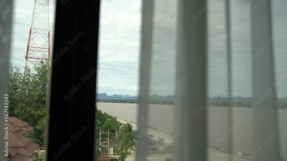Hotel guest open transparence curtain and window at deluxe room in morning with Mekong River view.
Hotel guest open transparence curtain and window at deluxe room in morning with Mekong River view.