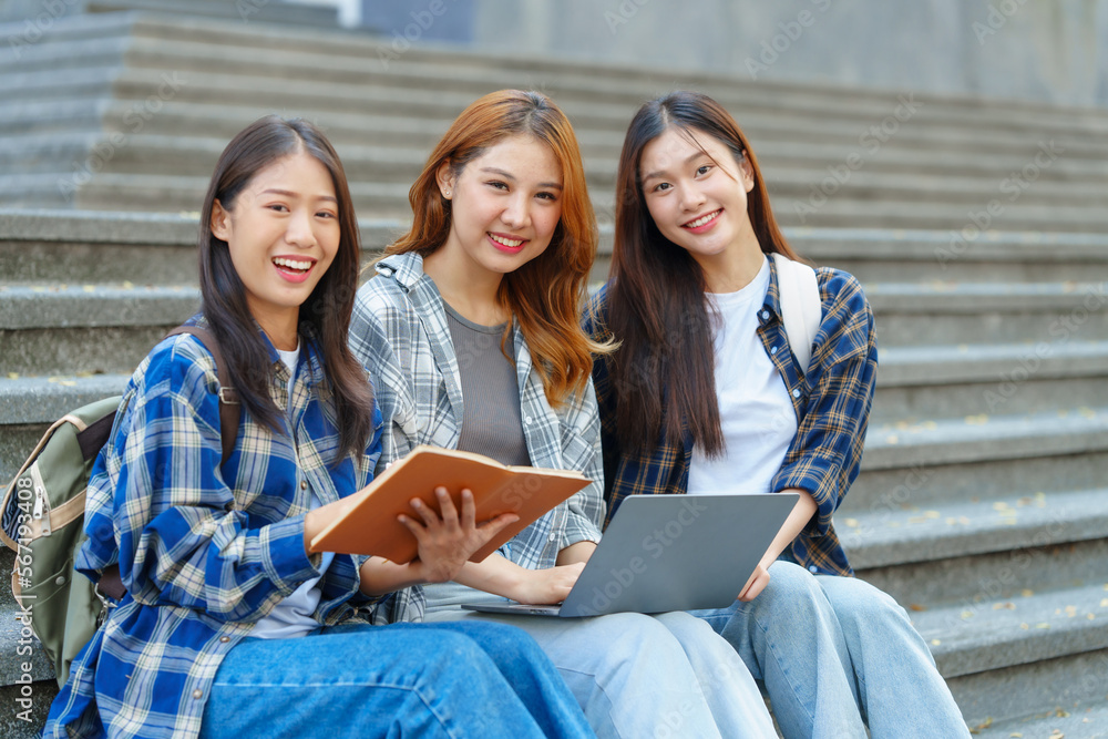 Attractive asian college student using laptop and tablet studying with group of friends together with english language classroom, social media and education concept. Attractive asian college student using laptop and tablet studying with group of friends together with english language classroom, social media and education concept.