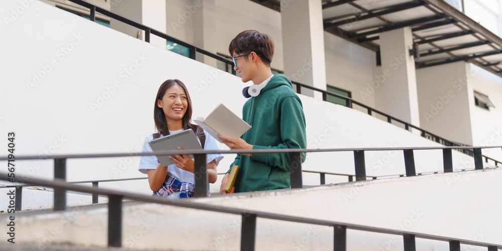 Attractive asian college student using laptop and tablet studying with group of friends together with english language classroom, social media and education concept.