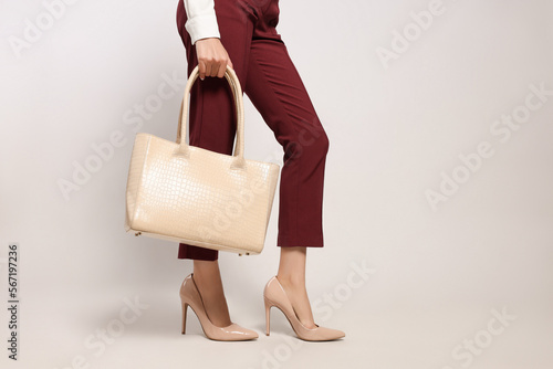 Young woman with stylish bag on white background, closeup