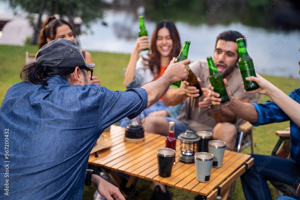 Fototapeta premium Group of diverse friend having outdoors camping party together in tent.