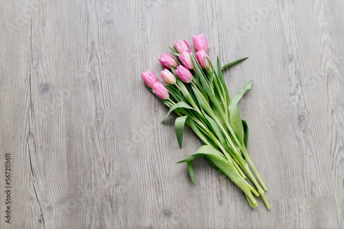 Pink tulips lie on a wooden surface. Spring background with flowers. Valentine s day card.