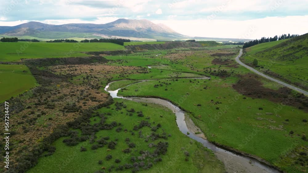 Aerial 4K epic view of a large and idyllic green valley through which a river and a small road pass in Mossburn area Aerial 4K epic view of a large and idyllic green valley through which a river and a small road pass in Mossburn area