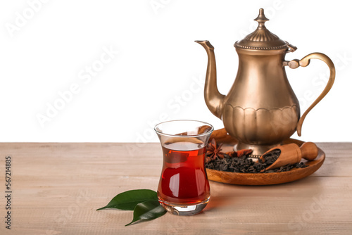 Cup of Turkish tea and teapot on wooden table against white background