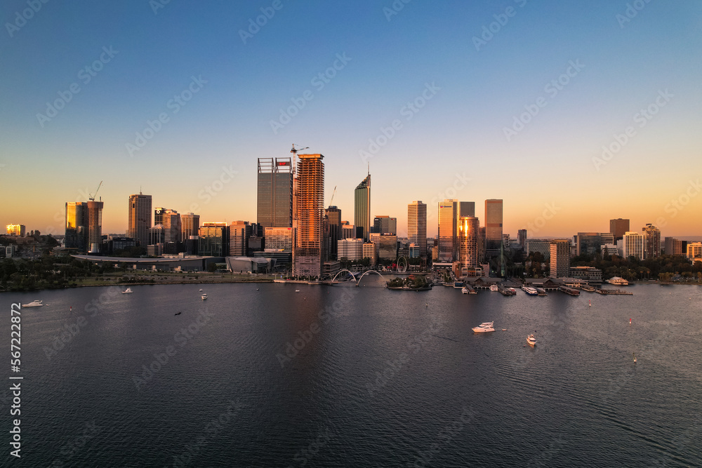 Aerial view of the Swan River and Perth skyline at sunset.
