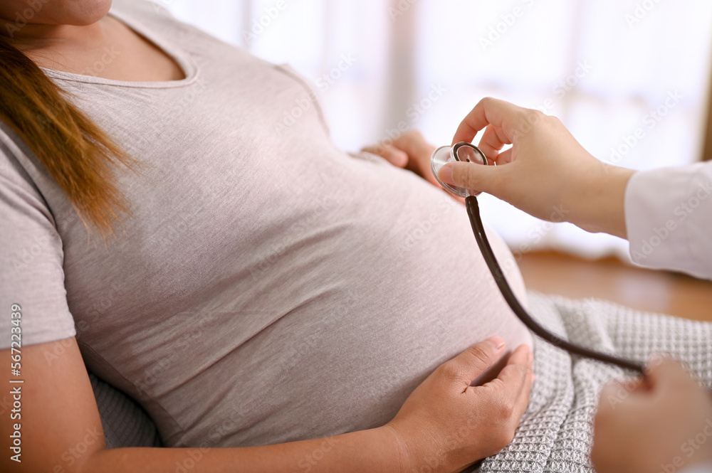 Close-up image of a professional doctor listening baby's heartbeat with a stethoscope
