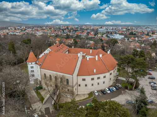 Aerial view of Pezinok (Bazin) medieval castle with restored red roof and medieval wine trading town center with Gothic church and traces of city wall in Slovakia 