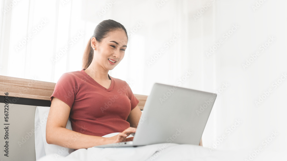 Young adult asian woman using laptop on bed for telemedicine mental health or shopping online Young adult asian woman using laptop on bed for telemedicine mental health or shopping online