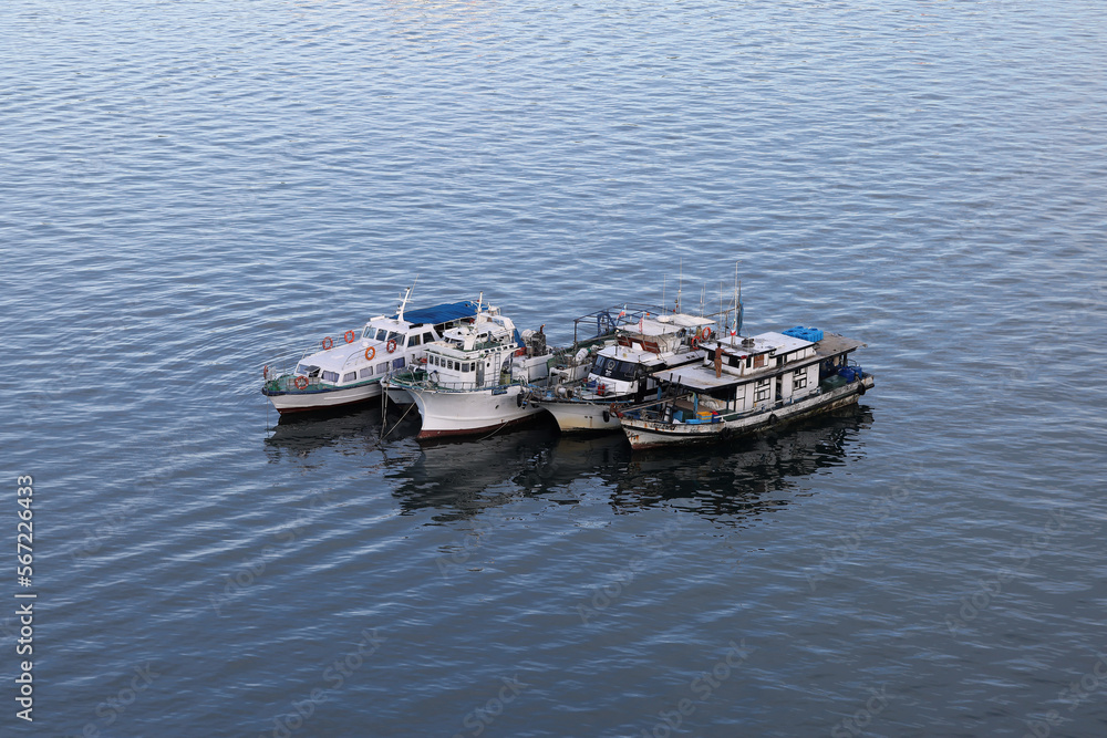 ships boats fishing trollers on ocean sea water of south China sea bay kota Kinabalu sabah
