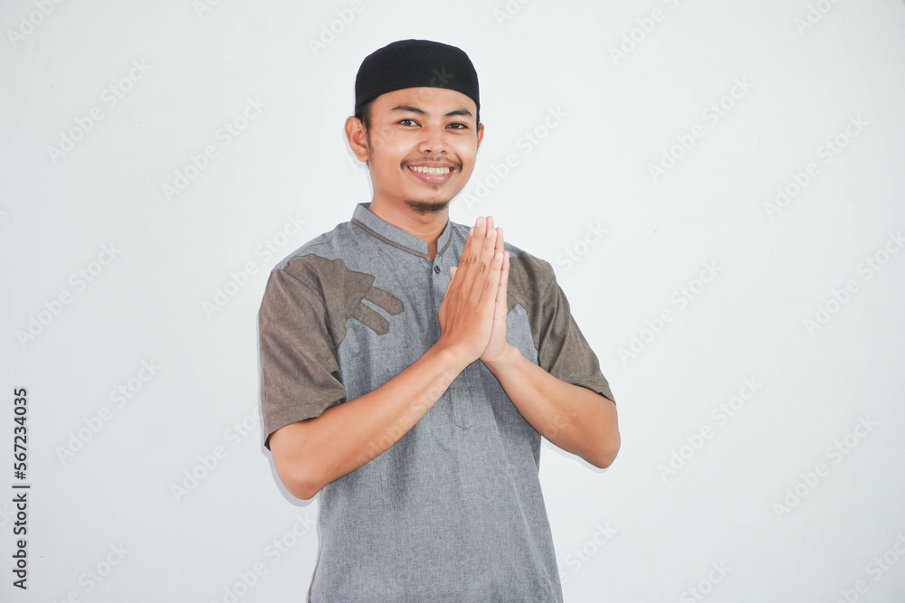 young Asian Muslim man wearing koko clothes smiling to give greeting during Ramadan and Eid Al Fitr celebration isolated on white background young Asian Muslim man wearing koko clothes smiling to give greeting during Ramadan and Eid Al Fitr celebration isolated on white background
