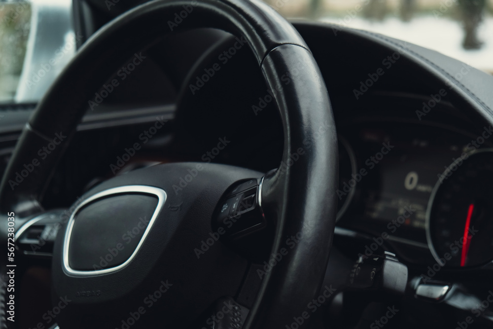 Black luxury modern car Interior. Steering wheel, shift lever and dashboard. Detail Automatic gear stick. Part of leather seats with stitching climate control, speedometer