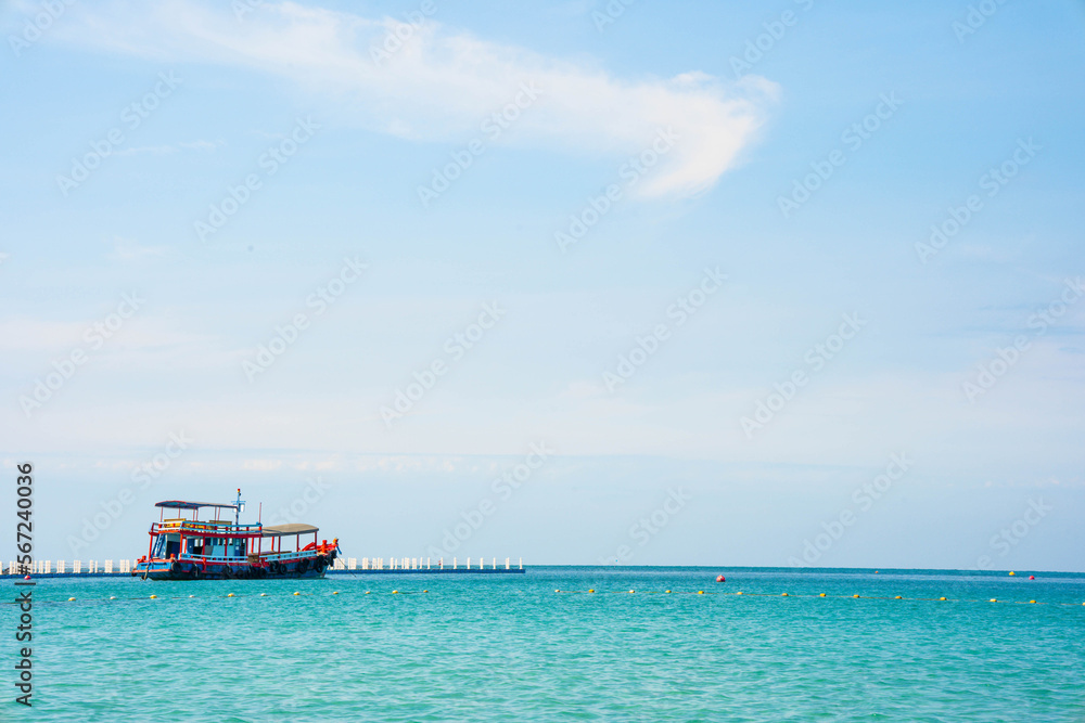 Passenger ship or ferry at the pier on the background of the blue sea, the concept of summer tourism, active recreation in Thailand