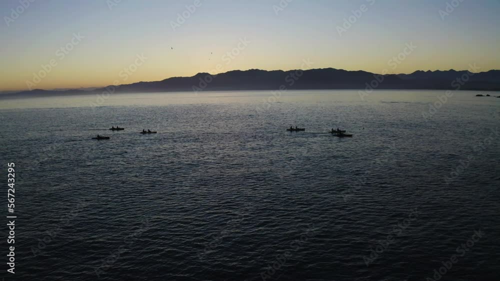 Kayaking in the ocean at Kiakoura New Zealand during a beautiful sunset with a group Kayaking in the ocean at Kiakoura New Zealand during a beautiful sunset with a group
