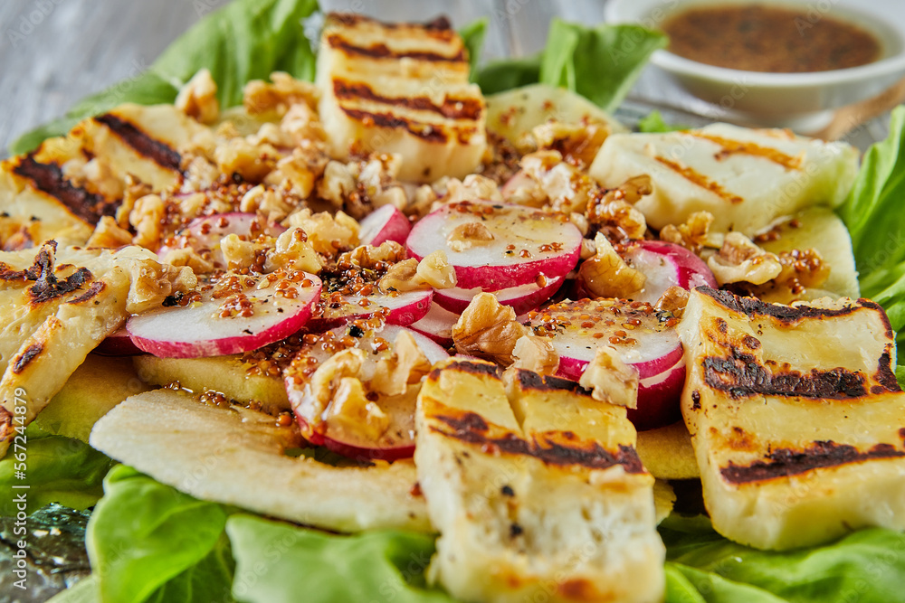 Apple salad, lettuce and halloumi cheese on wooden