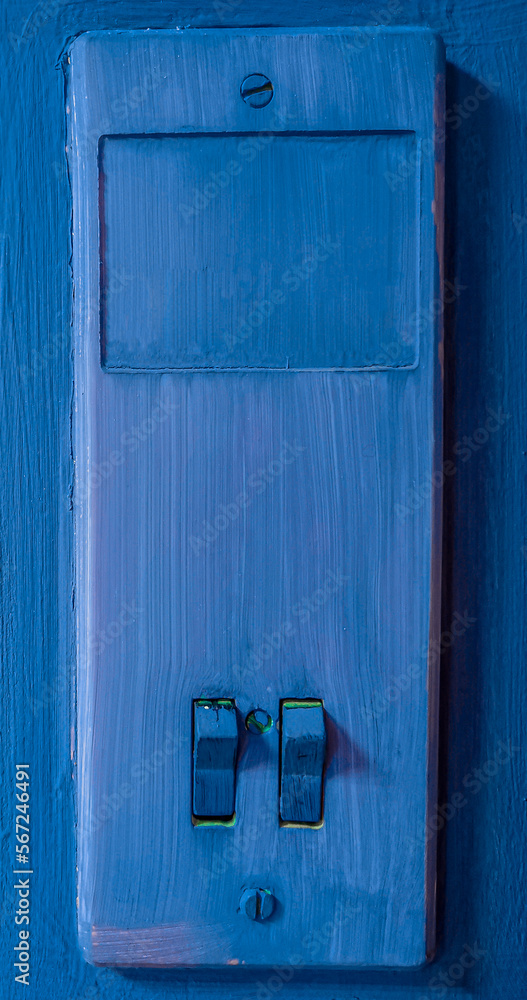 Blue old light switch on the wall close-up. Blue old light switch on the wall close-up.