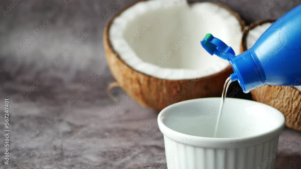 pouring coconut oil in a container on table pouring coconut oil in a container on table