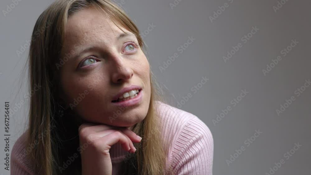 Portrait of a beautiful woman staring and blinking with a serious and ...