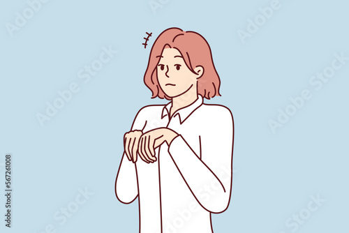 Young girl stands like puppy or bunny, bending palms near chest in pose symbolizing obedience and humility. Attractive woman in white shirt looks at screen in embarrassment