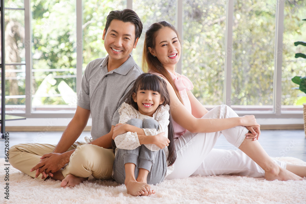 Real estate and mortgage concept : Family with child having fun in new home. Joyful first-time buyers in living room. Real estate, residential mortgage, moving into dream house.