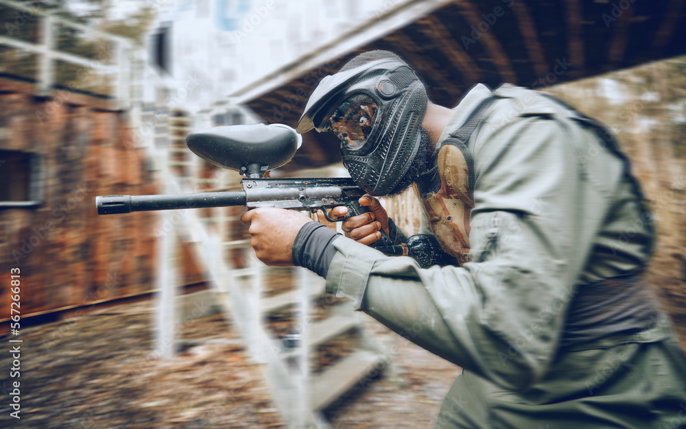 Fototapeta premium Paintball, black man and games, gun and target, sport with fitness and battlefield challenge, war soldier outdoor. Motion blur, extreme sports and exercise, shooting range and military mission