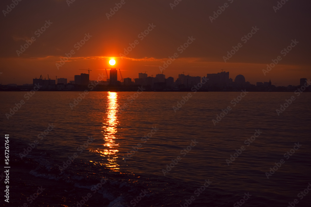 Naklejka premium Sunset over the city, Batumi , Adjara, Georgia. sunlight cityscape view of Batumi city at golden hour. Black Sea port of Batumi, capital of Adjara. Sun set. panorama of the city of batumi at sunset.