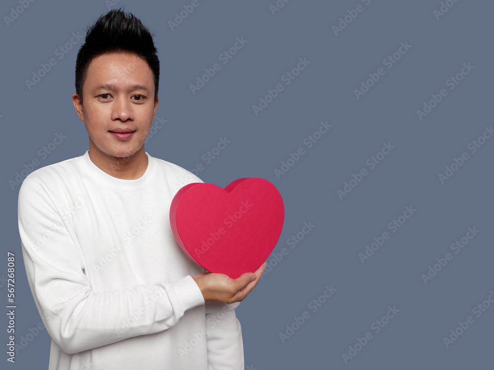 Man holding red heart shape isolated on plain background. Man holding red heart shape isolated on plain background.