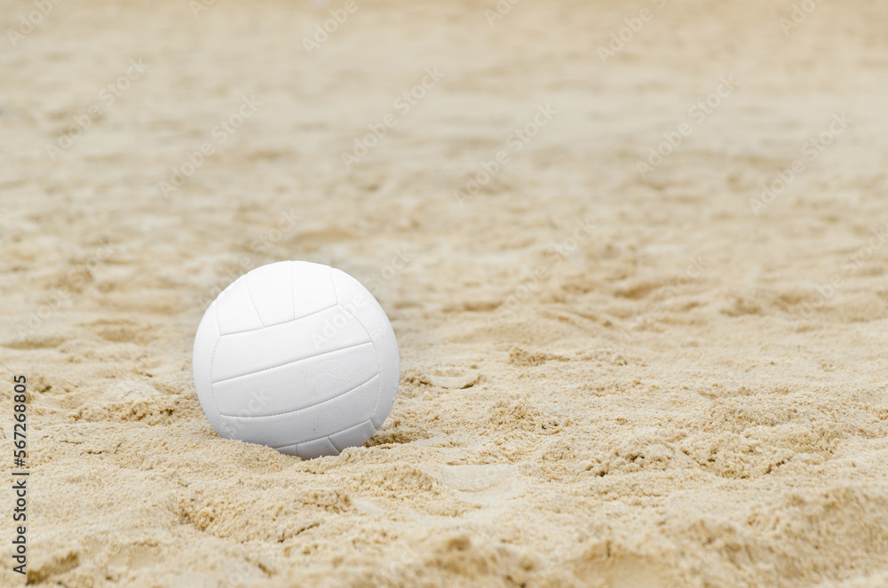 white volleyball ball on sand on beach. Equipment for active beach recreation, outdoor sports.