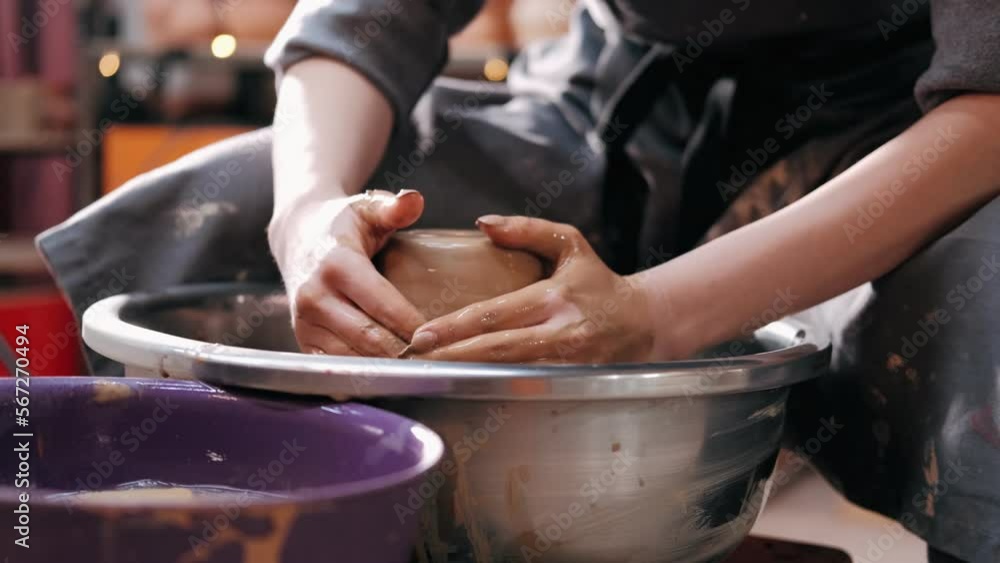 Close up of hands working clay on potter's wheel. Potter shapes the