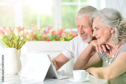 portrait of a happy old couple using tablet at home