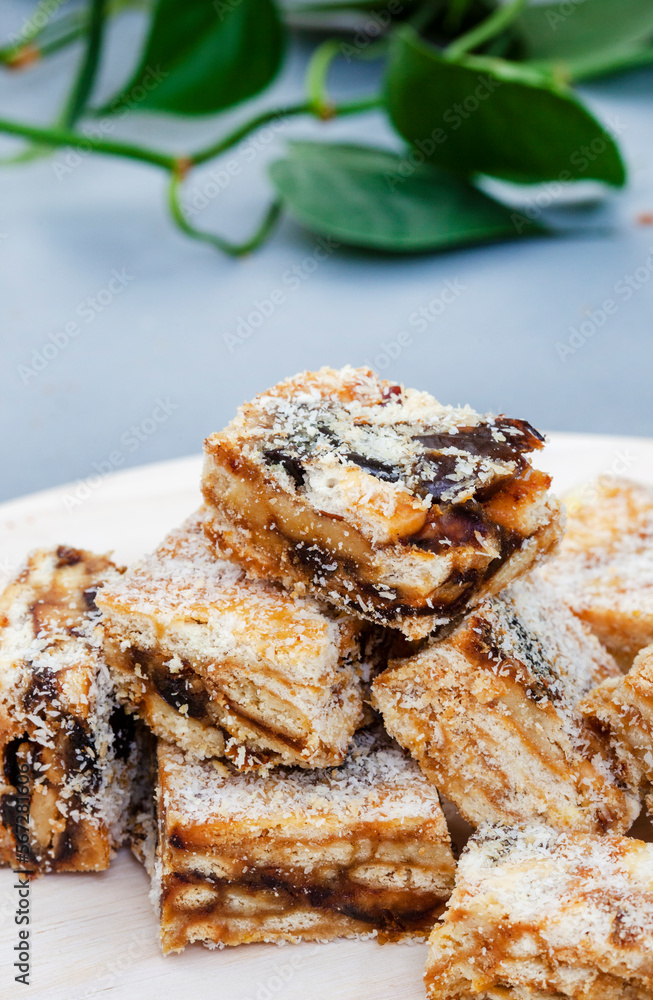 classic date squares sprinkled with coconut on light wooden surface
