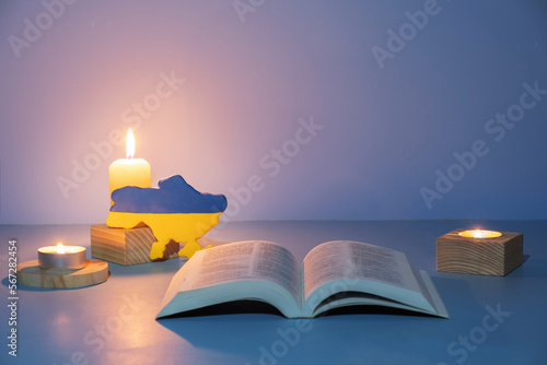 Christian Holy Bible with candles lighting on blue background