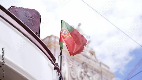 Portuguese flag on famous red tram 28 in front of Commerce Square, Praca de Comercio grand plaza in Lisbon, Portugal. Tourist landmark, travel destination in Portugal.