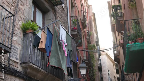 View on narrow street in Gothic Quarter of Barcelona. The central and oldest part of the Old Town. History Center. Narrow streets of Barcelona. Small square. Clothes. High quality 4k footage photo