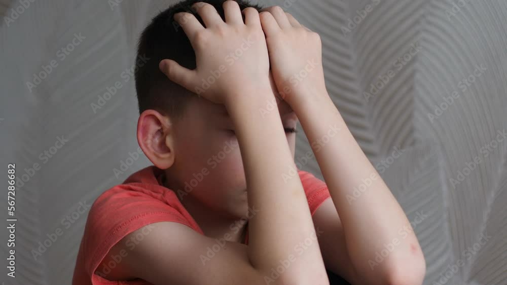 portrait sad depressed caucasian boy 9 years old covers his face with his hands is experiencing a loss.the child is sad thinking. the boy worries about the loss being inside portrait sad depressed caucasian boy 9 years old covers his face with his hands is experiencing a loss.the child is sad thinking. the boy worries about the loss being inside