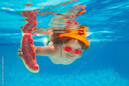 Summer vacation with child. Child swim underwater in the swimming pool hold watermelon. © Volodymyr