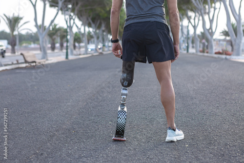 Crop runner with artificial blade leg standing on asphalt road