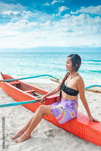 Attractive woman posing in colorful swimwear,on a boat,White Beach,Moalboal,Cebu Island,Philippines.