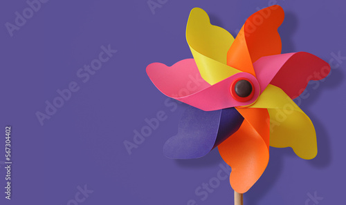 Flat lay Rainbow pinwheel on purple background, copy space