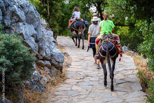 Girl riding a donkey to visit Cave of Diktaion Andron. photo