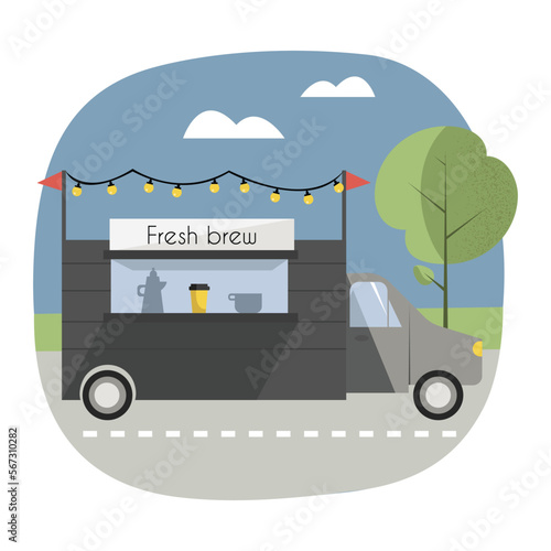 Scene with coffee truck, decorated with lights, standing on the road in a park or somewhere in the nature.