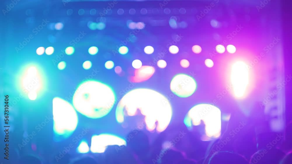 People silhouettes partying, cheering, raising hands up and jumping at rock concert in front of stage of nightclub. Bright colorful stage lighting with lens flares. Nightlife and entertainment concept People silhouettes partying, cheering, raising hands up and jumping at rock concert in front of stage of nightclub. Bright colorful stage lighting with lens flares. Nightlife and entertainment concept