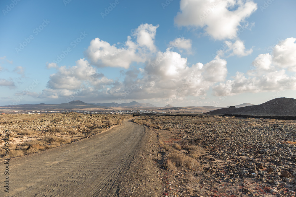 Beautiful sunset in a desert area with white clouds, mountains and town in the background, Fuerteventura Canary Islands.jpg