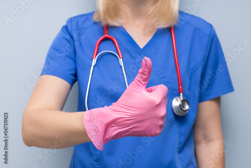 doctor in uniform in hospital holding thumb up.