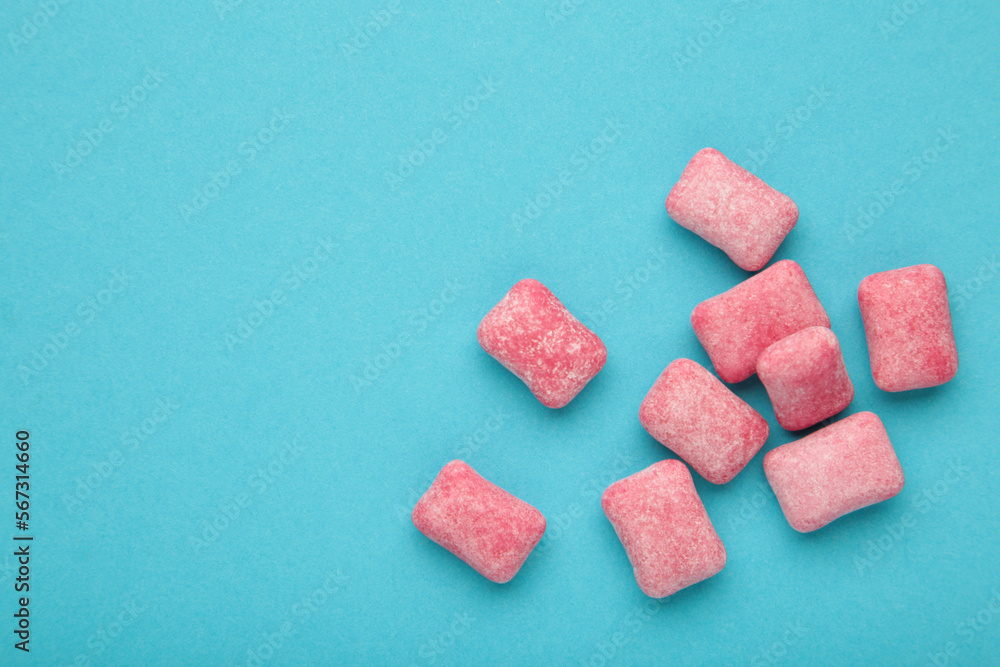 Chewing pink gum pieces on blue background. Space for text Chewing pink gum pieces on blue background. Space for text