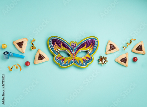 Hamantaschen Cookies, Carnival Mask, Noisemaker on Mint Green Background. Purim Celebration, Jewish Carnival Holiday Concept.