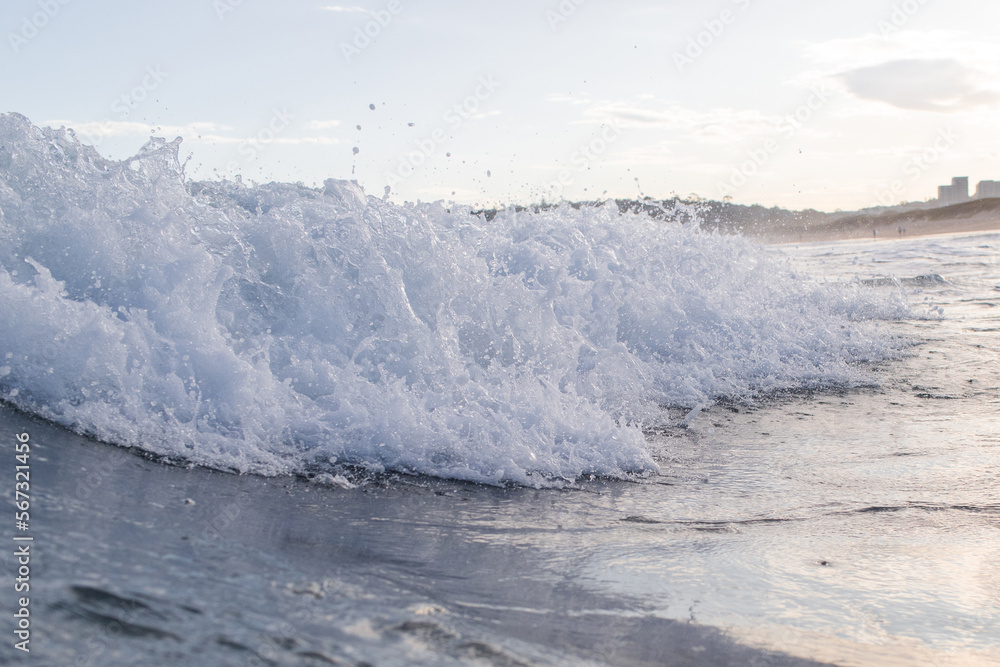 White wave foam on the beach shore.