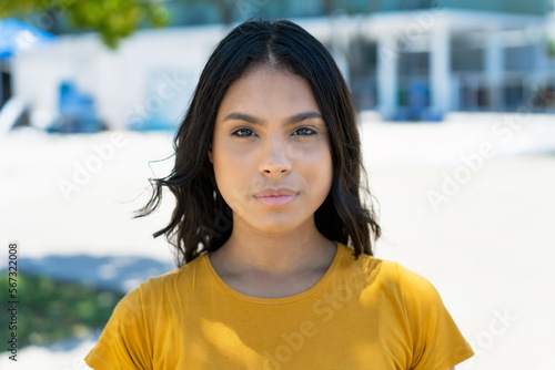 Portrait of serious mexican young adult woman with long black hair