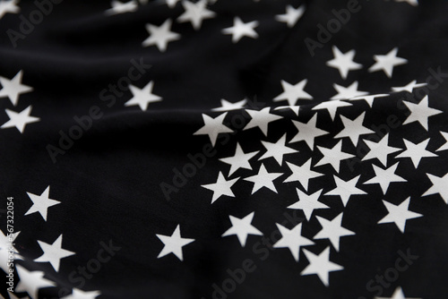 Black folded fabric with white stars pattern as texture background © kapichka