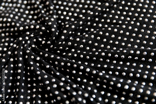 Black cotton folded fabric with dotted metal rivets as background